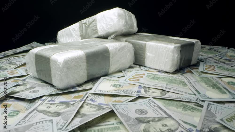 Slow push in towards bricks of drugs on table top of money. Stock ビデオ