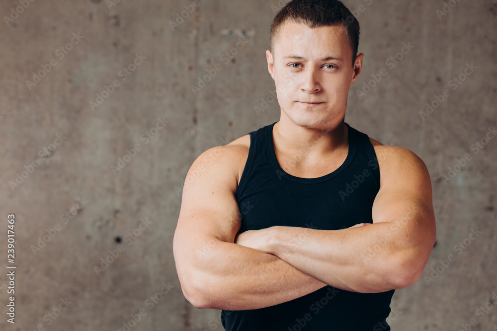 young confident strong sportsman standing with crossed arms at gym. close up photo. hobby, free time, lifestyle. copy space young confident strong sportsman standing with crossed arms at gym. close up photo. hobby, free time, lifestyle. copy space