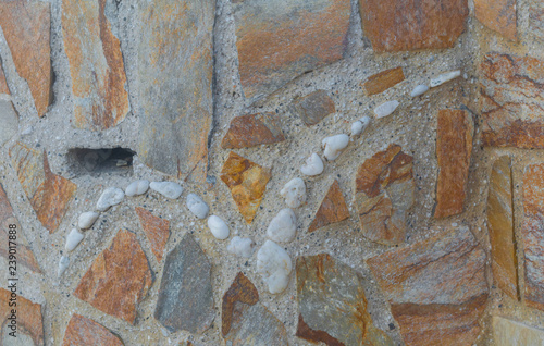 abulous bird created from white pebbles inside the wall. Stone bas-relief on the wall.Old stone wall outdoor on the city street on sunny day closeup. Wall,stone,architecture,old,vintage. photo