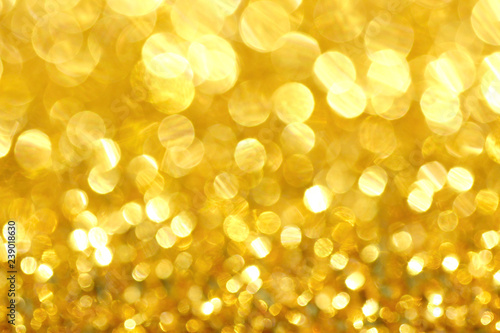 Defocused tele zoom light. Abstract gold bokeh glittering background 