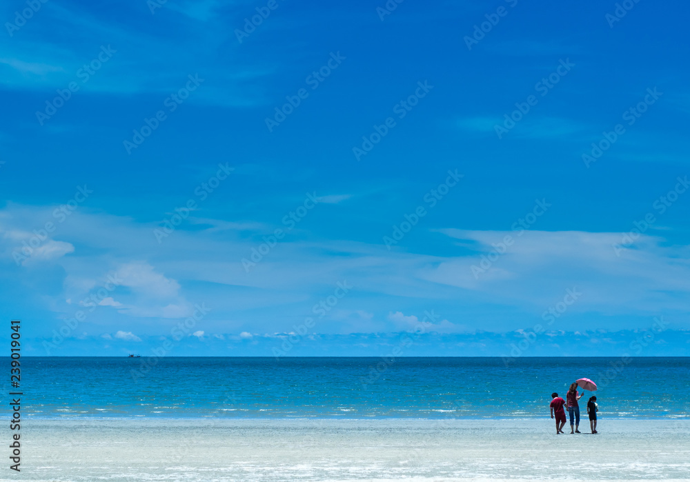 People on the beach wide view of sea and blue sky