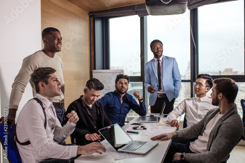 Fotografía African american Chief Executive represents new team member to multiracial group of colleagues sitting at the table at the Chief s cabinet