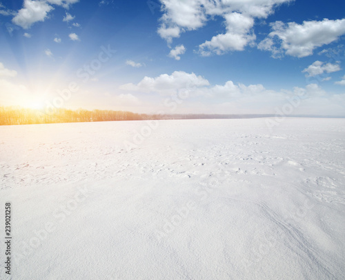 Snowcovered fields on  sky and sun. © Alekss