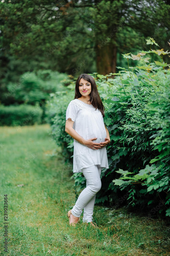 Beautiful pregnant woman relaxing outside in the park Beautiful pregnant woman relaxing outside in the park