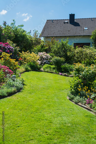 Fototapeta Naklejka Na Ścianę i Meble -  Garten mit Rasenfläche im Hochformat