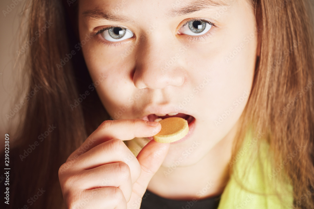 Sick girl with green scarf takes big yellow pill from disease in mouth. Sick girl with green scarf takes big yellow pill from disease in mouth.