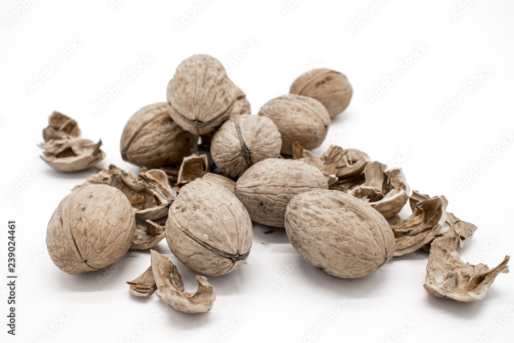 Walnuts on a white background, broken by a nutcracker Walnuts on a white background, broken by a nutcracker