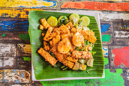 Gado-gado Indonesian salad served with peanut sauce. Ingredients: tofu, spinach, string beans, soy sprouts, potatoes, cucumber and boiled eggs photo