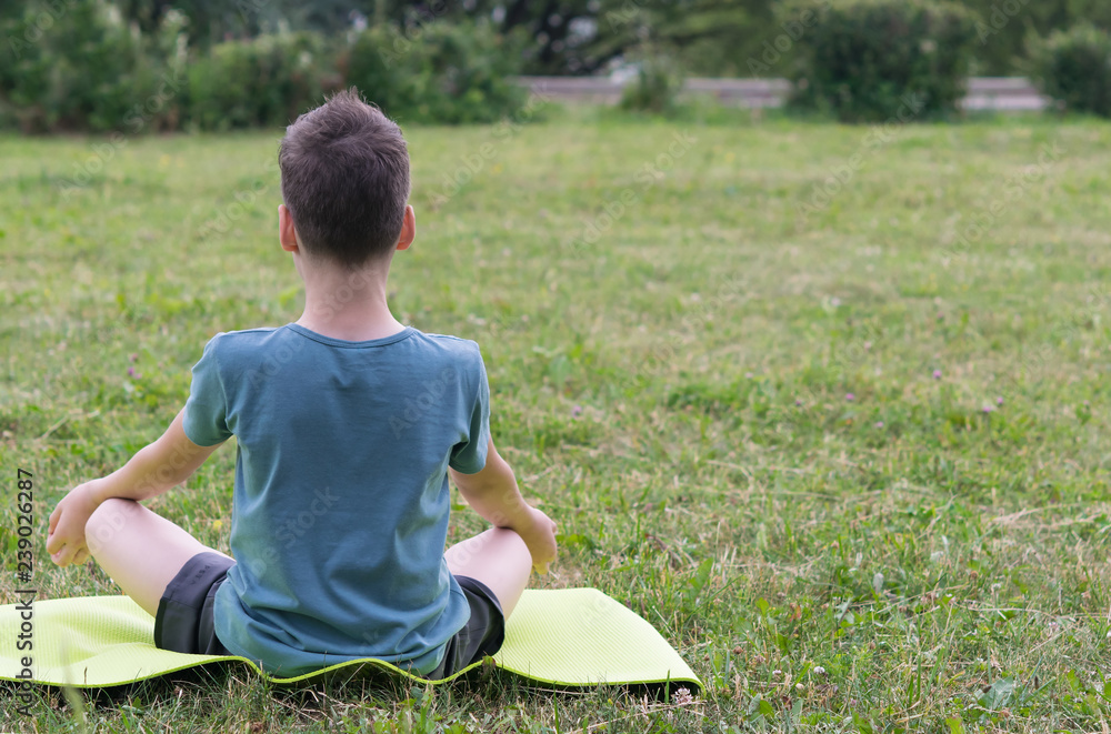 boy doing yoga outdoors in the park boy doing yoga outdoors in the park
