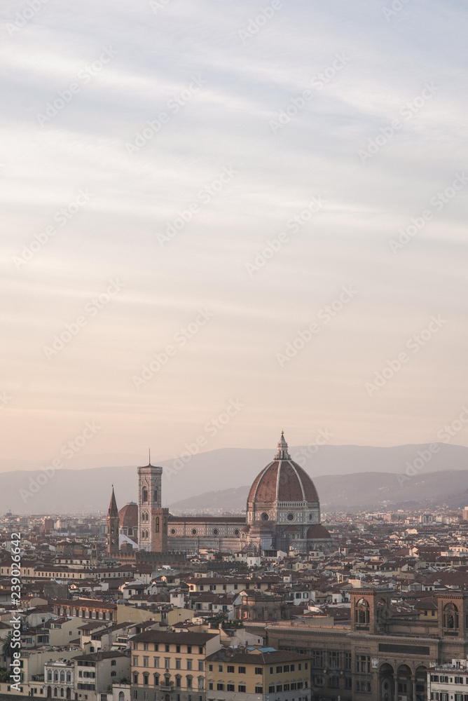 Vertical photo landscape of the city of Florence, Italy on a long-focus lens, view from the viewpoint of the cathedral Cattedrale di Santa Maria del Fiore in the evening time of the sunset.