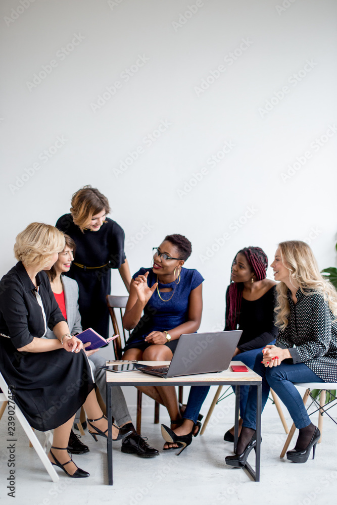 Φωτογραφία Crew of multiracial female co-workers watching video on netbook for new business project, making research, enjoying togetherness and positive emotions