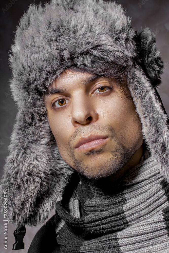 Joyful young guy in a warm fur hat; Joyful young guy in a warm fur hat;