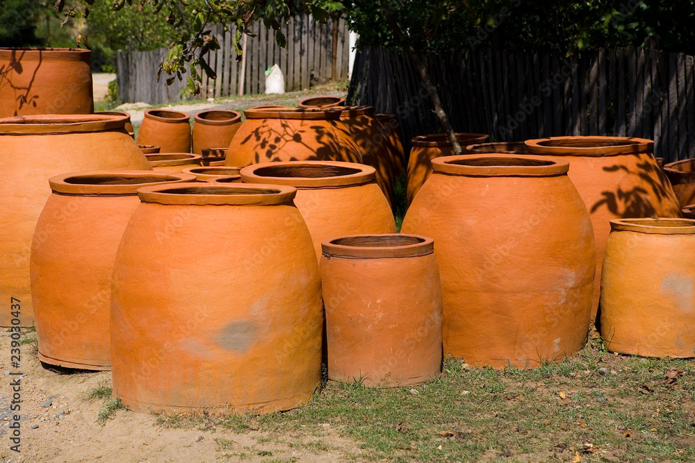 Many large earthenware jugs for wine are sold near the road. Many large earthenware jugs for wine are sold near the road.