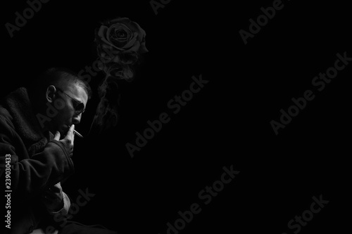 handsome male on black background smoking cigar, conveniently for quote, smoke manipulation, skull and rose smoke