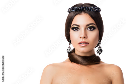 Portrait of beautiful brunette woman with big earring and shinny accessories. With hair around neck, perfect arabic makeup. Looking at camera. Isolate shot on white background. Front view. photo