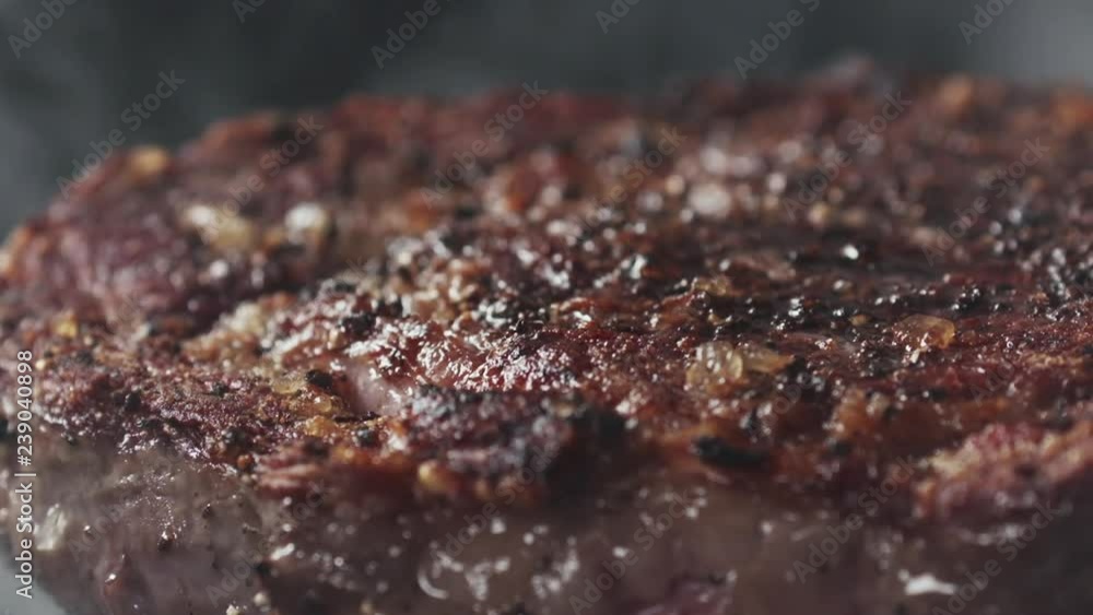Slide slow motion shot of cooking rib eye steak on grill pan Slide slow motion shot of cooking rib eye steak on grill pan