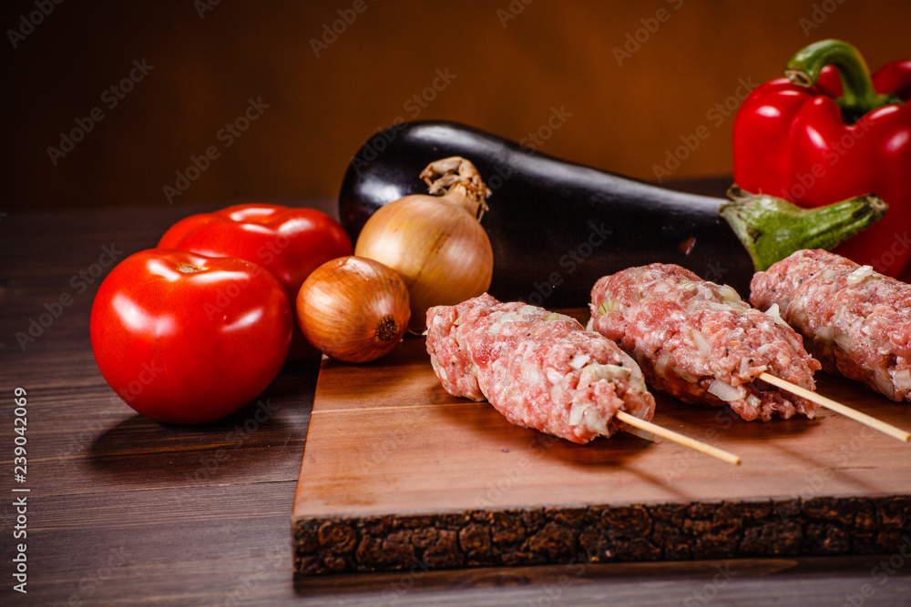 Raw hot dogs on cutting board and vegetables Raw hot dogs on cutting board and vegetables
