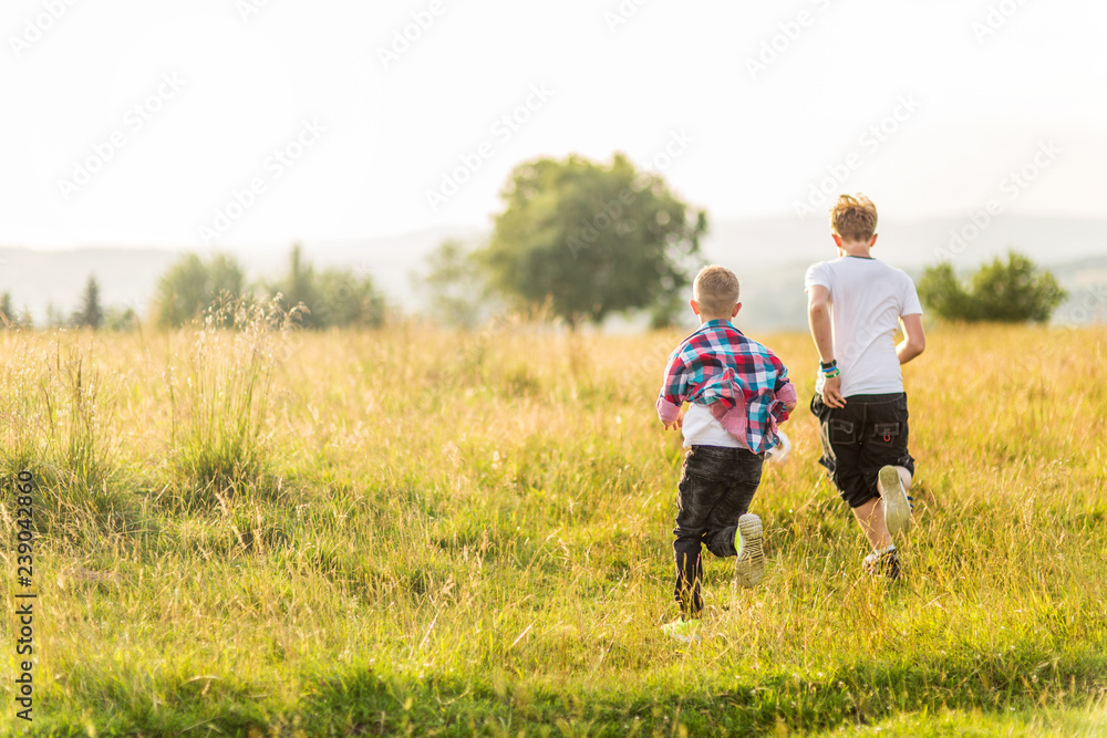 Boys running in the meadow, having fun