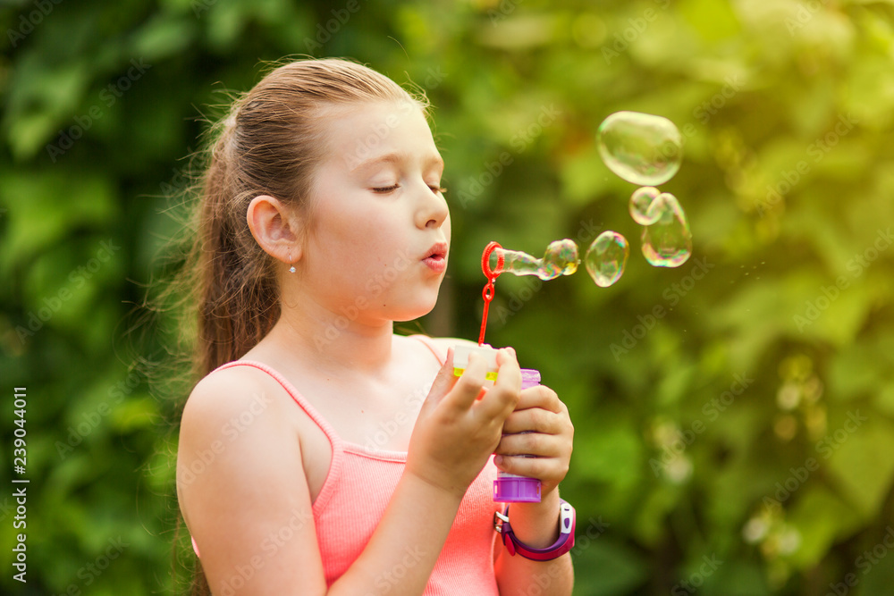 Portrait of a young girl blowing soap bubbles Portrait of a young girl blowing soap bubbles