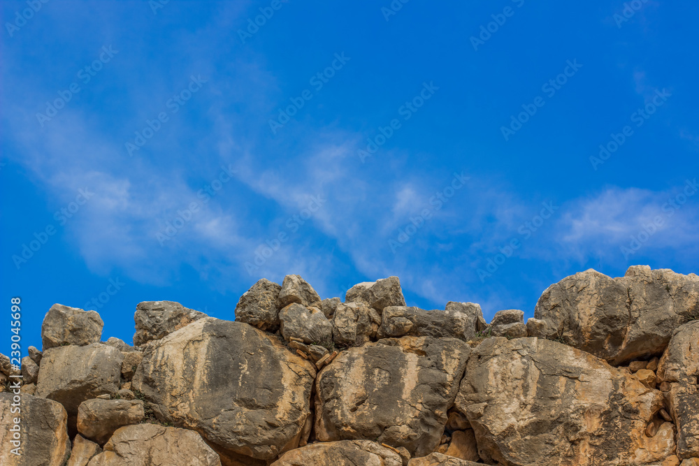 old stone  wall background material texture and board with empty vivid blue sky, copy space