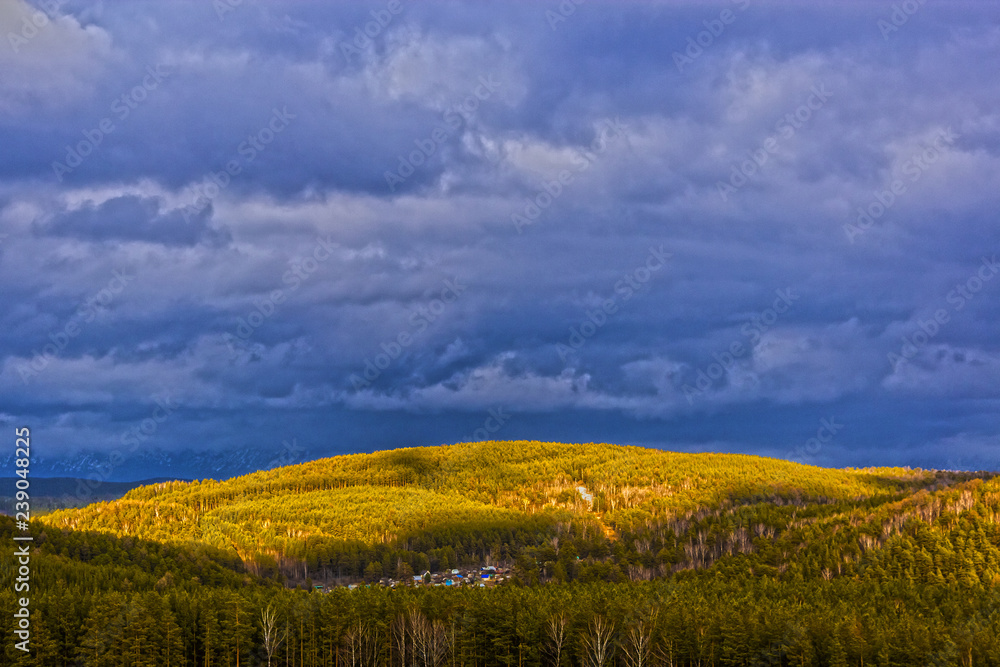 Fototapeta premium grey stormy clouds above the green mountain