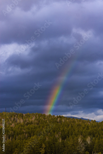 rainbow on gray sky background in mountans