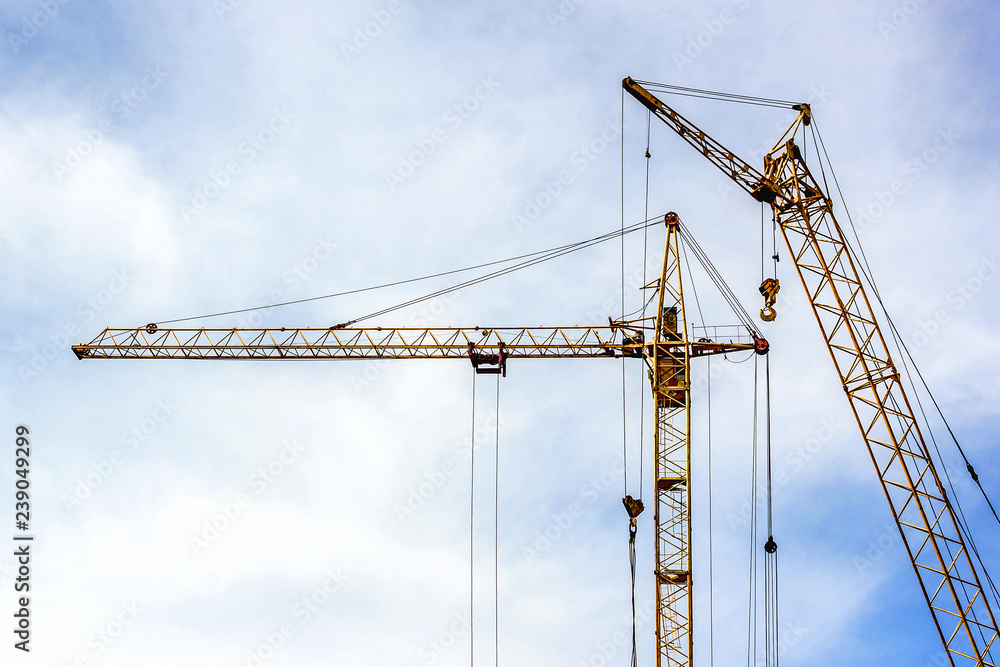 two tower cranes on cloud sky background two tower cranes on cloud sky background