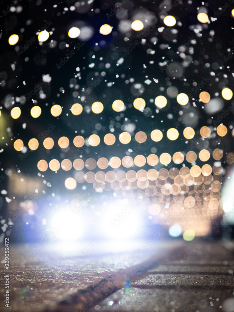 Slippery streets: Defocused car driving on snowy street with christmas decoration