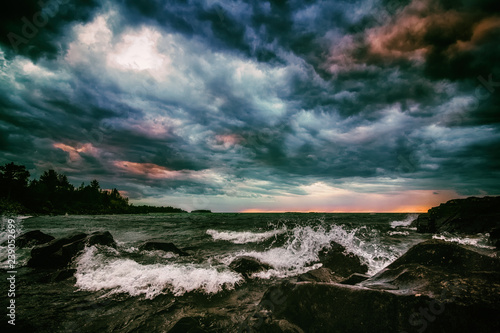 Colorful Storm Clouds Over Turbulent Sea. Dramatic Cloudscape and Seascape Background with Copy Space. Stormy sky over Lake Superior in Michigan s Upper Peninsula. Moody stylized seascape.