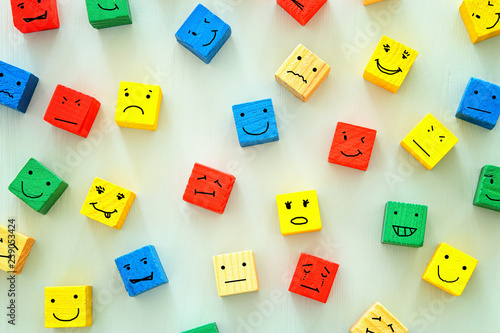 concept of Different emotions drawn on colorfull cubes, wooden background.