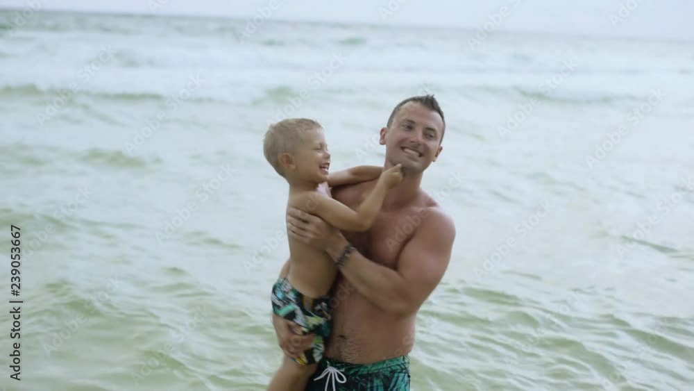 Young charming father has fun with his happy son on beautiful lonely beach 4k Young charming father has fun with his happy son on beautiful lonely beach 4k