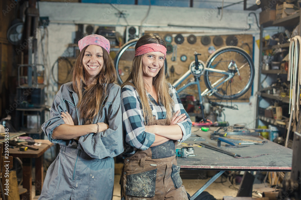 two young women in a workshop posing