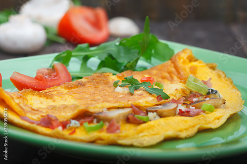 Egg omlet with ham and mushrooms on green plate. Traditional, healthy breakfast .