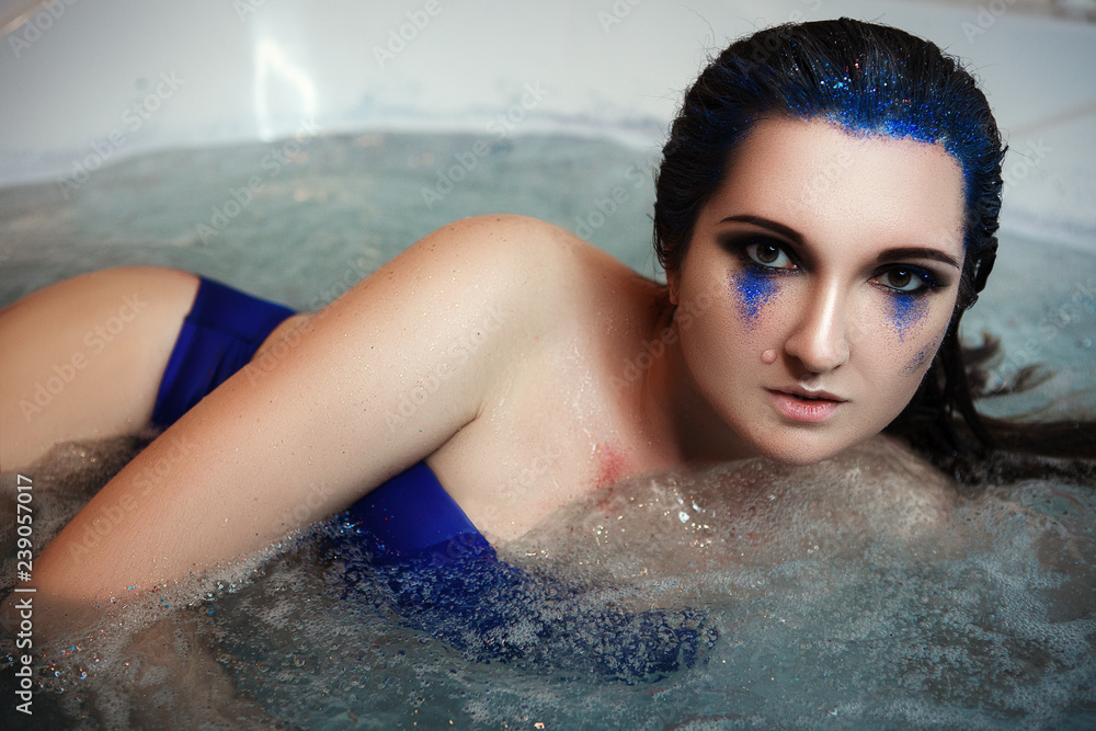 Model is posing in a bath with glitters