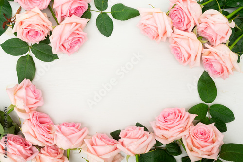 Rose fresh natural pink flowers frame on table from above with copy space, flat lay scene