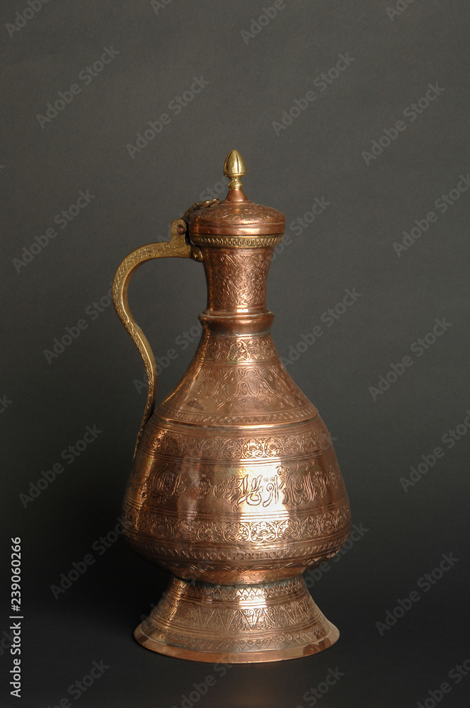 ancient oriental metal jug on dark background. antique bronze tableware ancient oriental metal jug on dark background. antique bronze tableware