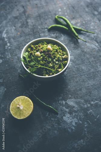 Hot and spicy green chilli chutney using hari mirch, cumin seeds, lemon juice and coriander. served in a bowl. selective focus