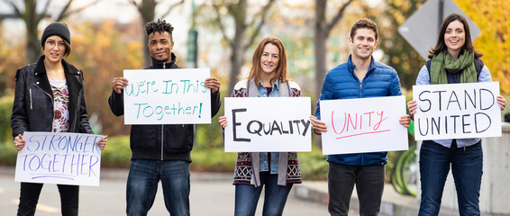 Group of five people holding signs with message of unity and equality