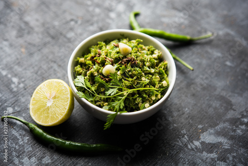 Hot and spicy green chilli chutney using hari mirch, cumin seeds, lemon juice and coriander. served in a bowl. selective focus photo