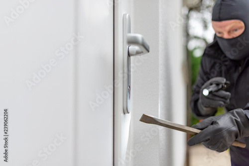 Einbrecher will mit einer Brechstange eine Haustür aufhebeln