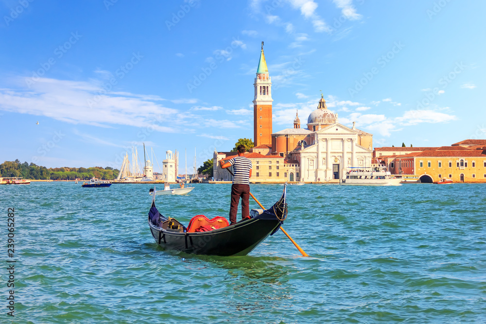 Fototapeta premium Gondolier w gondoli w pobliżu San Giorgio Maggiore w Wenecji, Włochy