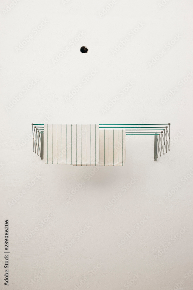 tendedero de pared con 2 trapos de cocina a rayas tendidos y fondo pared  blanca Stock Photo | Adobe Stock