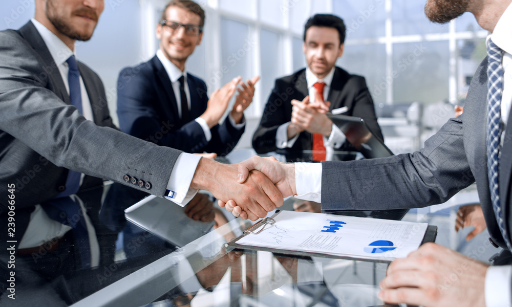 handshake business partners over the Desk