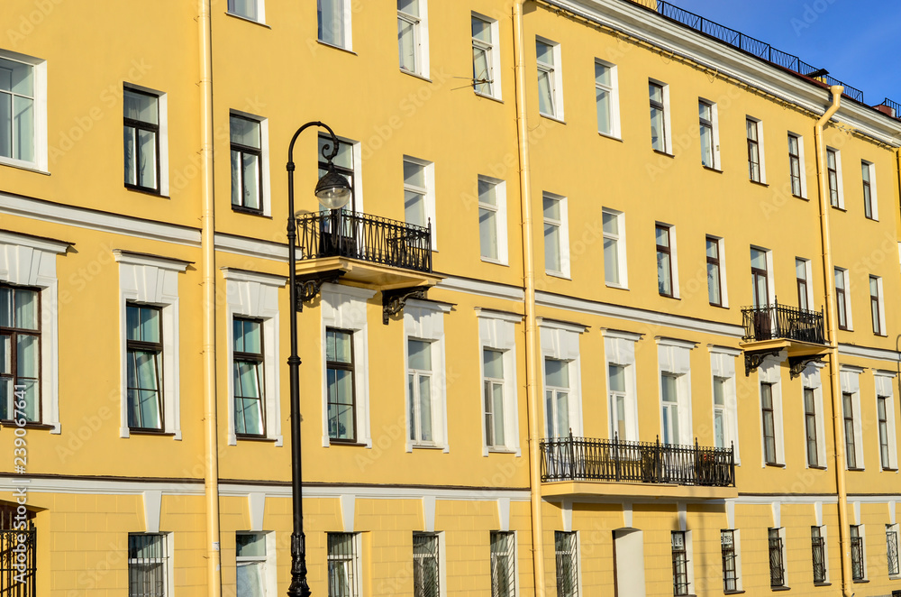 The building is yellow with white Windows and black metal balconies.