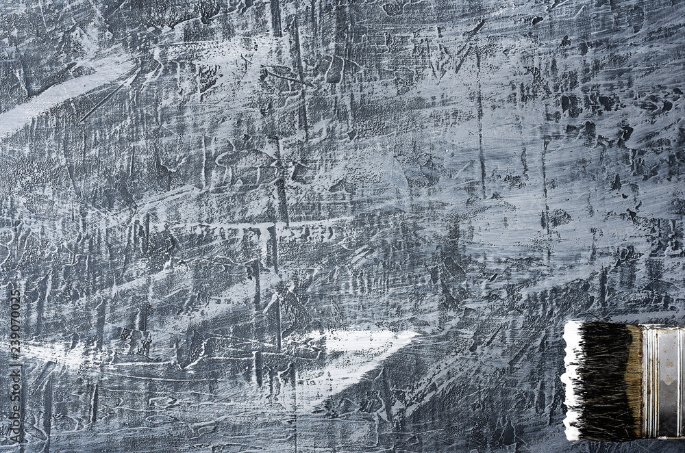 part of the brush in black and white paint on a background of a concrete painted gray background from the top right to the bottom