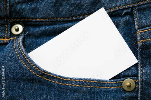 blank white paper or card in front pocket of blue jeans with copyspace for sale text or business concept