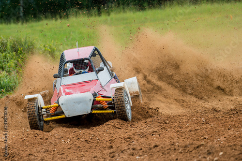 Autocross on a dusty road. Car in competition up the road on a dirt road