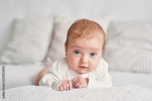 Cute newborn baby girl, three months old, lies in blanket. Baby goods packaging template. Closeup portrait of newborn baby with smile on face. Healthy and medical concept. Eco conception.