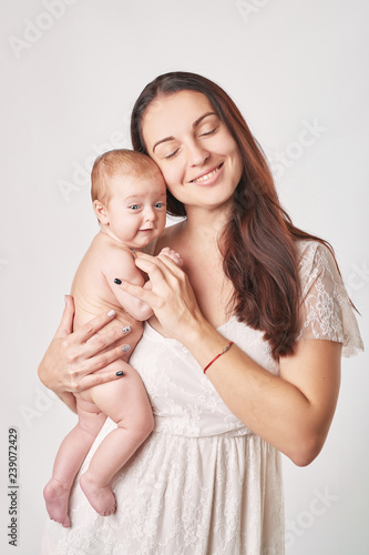 Portrait happy smiling mother with baby on white background. Happy smiling mother with baby having fun together on white background. Young beautiful woman with small child in her arms.