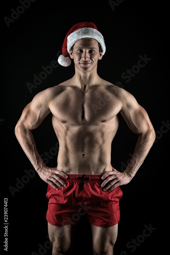 Sexy muscular man in santa hat. Christmas shopping. Present for Xmas. New year party. Santa claus man. Office christmas party. Happy winter holidays. Red. Sport is our life. Feast of Christmas © be free